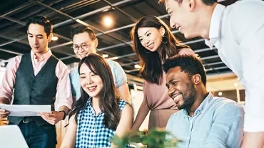 A diverse group of six colleagues collaborating in a modern office setting.